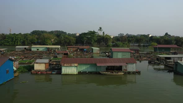 Slow tracking drone shot along floating fish farming community in Bien Hoa on the Dong Nai river, Vi alt