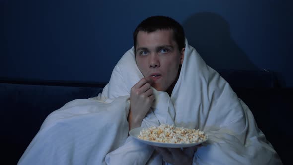 Shocked Handsome Caucasian Man Watches TV Movie Blanket Evening Eats Popcorn Sofa Home He Is Very alt