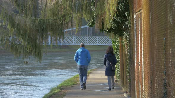 Man and woman walking by the river alt
