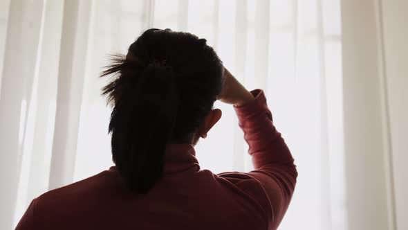 Silhouette of woman performing self head massage. Headaches concept. alt