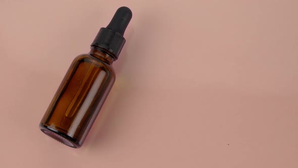 Glass Bottle of Hyaluronic Acid Face Serum in Water Splash on Beige Background