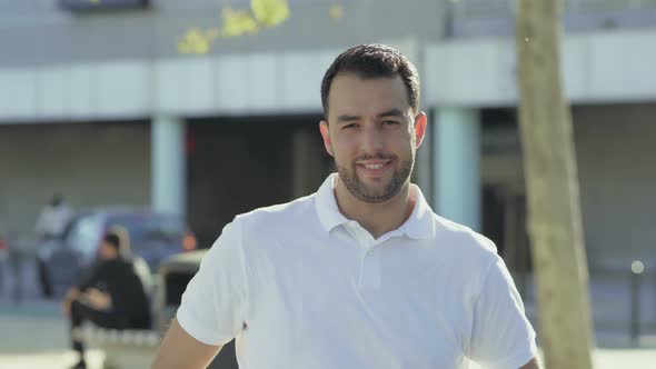 Smiling Young Man with Hand on Chin Looking at Camera alt