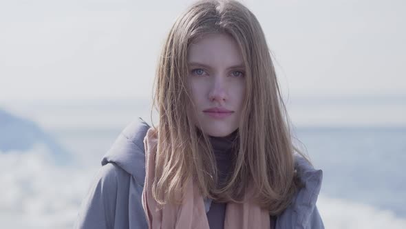 Portrait of Adorable Confident Young Blond Woman with Long Hair and Blue Eyes Looking in the Camera alt