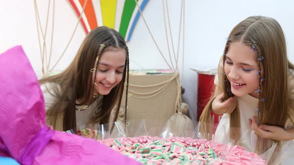 Smiling Girls Choose Colored Candies alt