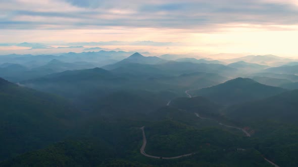 4K Flying through the clouds above mountain tops alt