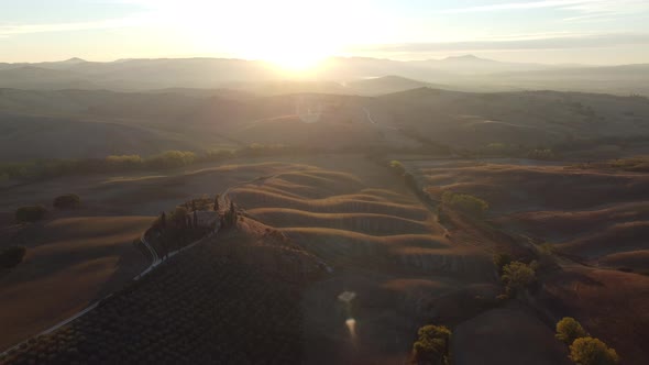 Val d'Orcia Valley Farmhouse, Cypress Trees and Rolling Hills Tuscany Aerial at Sunset Autumn alt