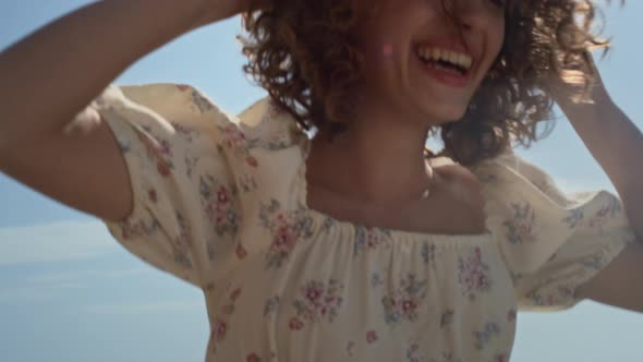Excited Woman Jumping Holding Straw Hat on Head Closeup alt