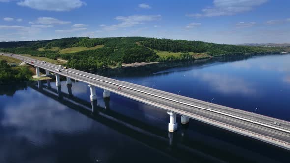 AERIAL Fly Over Traffic Bridge Highway Roadway Road Way and Blue River with Trees Forest, Europe