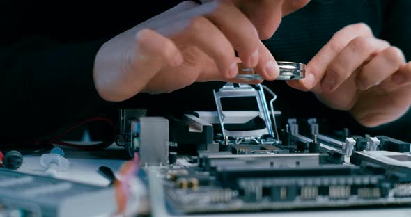 Technician Man Repairs PC By Studying with Magnifier CPU Micro Processor