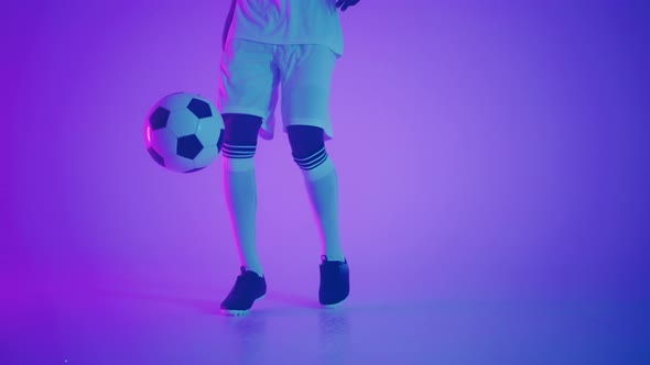 Young African Footballer is Dribbling Ball and Doing Keepups in Studio Closeup of Feet of Player alt