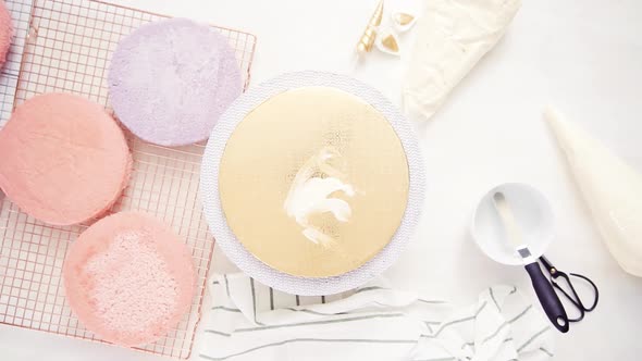 Flat lay. Assembling pink and purple cake layer to make unicorn cake for little girl's birthday part alt