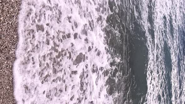 Sea Wave on Stone Beach in summer with white foamy on summer. Nature with sea and beach. travel or t