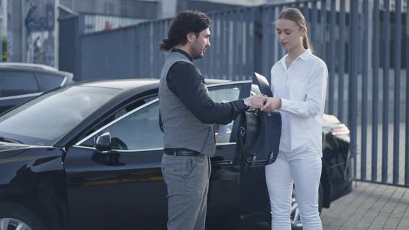 Young Woman Paying Man for Briefcase in Urban City Leaving alt