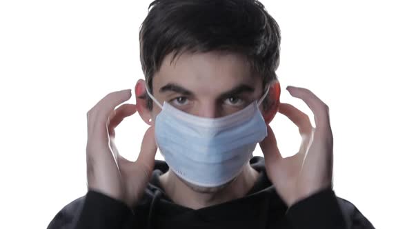 Portrait of a Young Man Who Wears a Medical Mask on White Background, Isolate