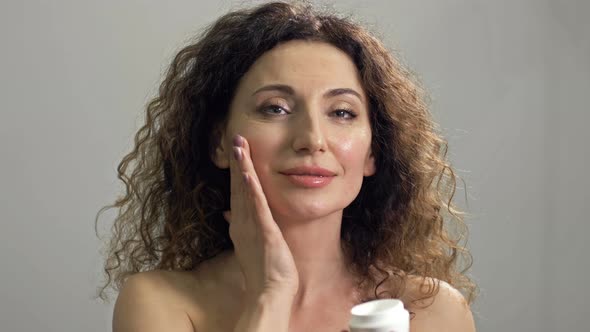 Beautiful Mature Woman Holding Jar of Skin Cream for Face alt