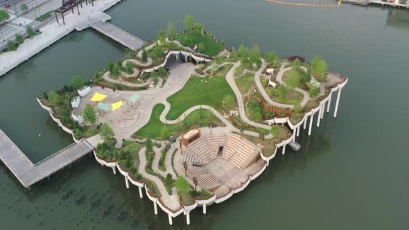 An aerial view over Manhattan's Little Island, a public green space taken on a sunny day. The drone alt