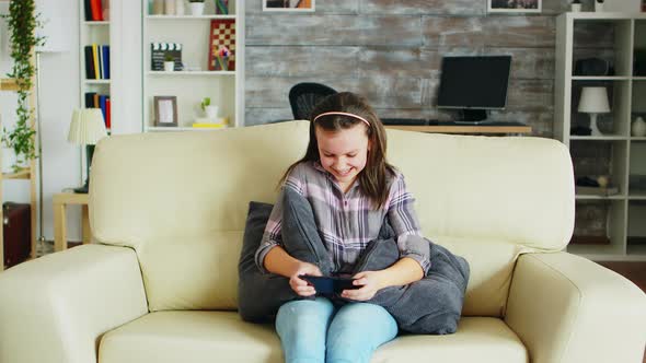 Excited Little Girl Playing Video Games on Her Phone alt
