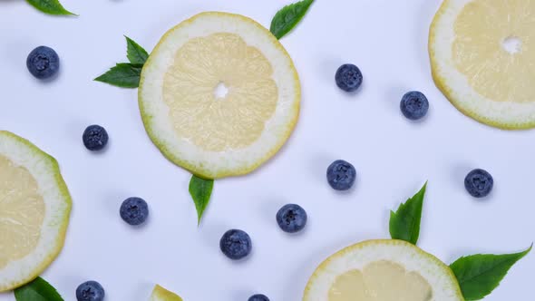 Rotation Background of Blueberries and Lemon Slices on a White Background the Concept of a Healthy