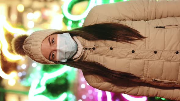 Close Up Portrait of Caucasian Young Female in Medical Face Mask Standing in Decorated Xmas City