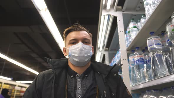 Portrait of Young Man with Medical Face Mask Walking at Supermarket. Guy Going at Shop with alt