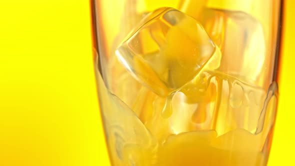 Super Slow Motion Shot of Pouring Fresh Orange Juice Into Glass with Ice Cubes at 1000 Fps alt