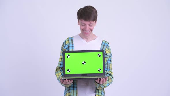 Happy Young Handsome Man Showing Laptop and Looking Surprised alt
