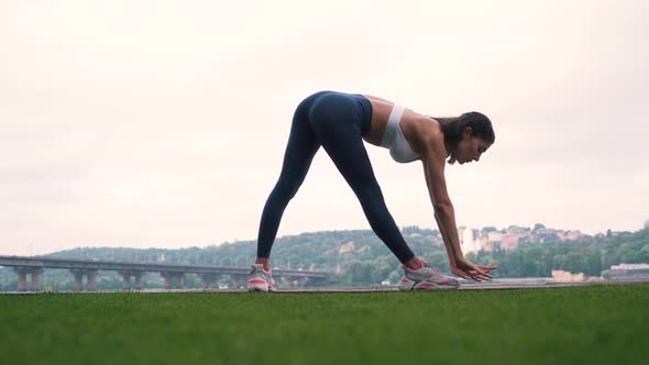 Girl Doing Exercises on the Background of the City