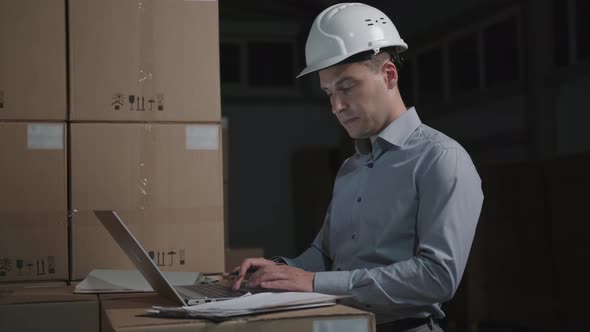 Man in a Helmet Near Boxes. Logistics, Delivery and Storage Concept alt