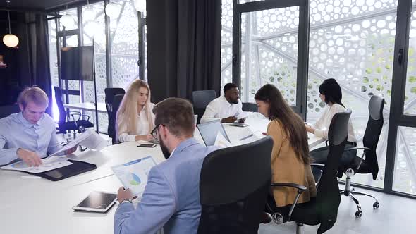 Business Multiracial Team Working Under Their Joint Project, Learning Different Infographics alt