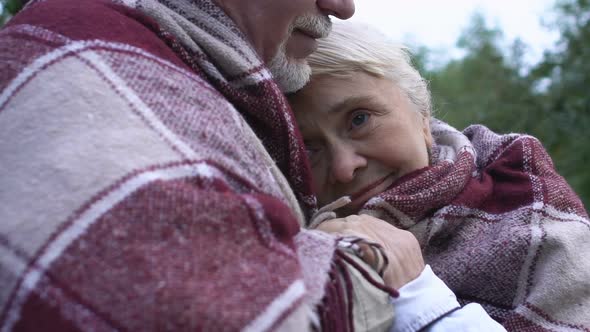 Aged Man Cuddling and Comforting His Mature Wife Elderly Couple Wrapped in Plaid