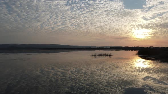 Clouds reflect on the river at sunset