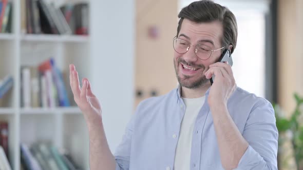 Portrait of Man in Glasses Talking on Smartphone alt