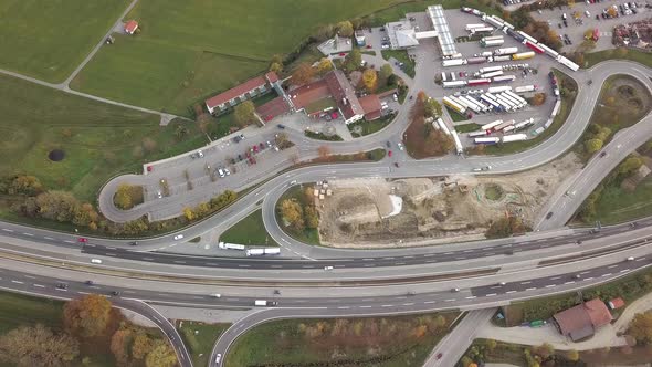 Top down aerial view of highway interstate road with fast moving traffic and parking lot with  alt