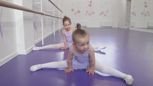 Two Cute Little Ballerinas Girls Stretching at Ballet Class Doing Splits alt