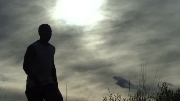 Male walking up hill and relaxing alt