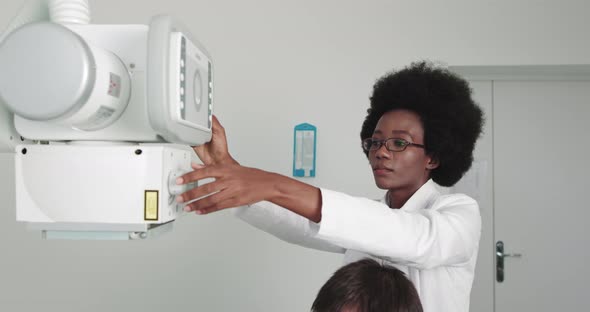 In the Hospital Female Technician Adjusts XRay Scanner Machine alt