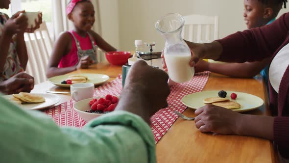 Three generation african american family having breakfast together at home alt