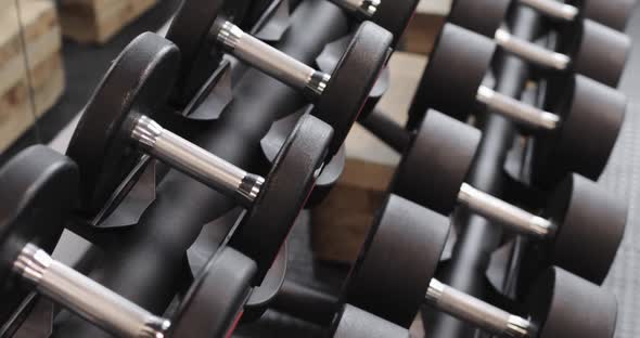Dumbbells for Strength Training are on a Stand in the Gym of a Modern Sports Club