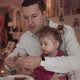 Father feeding pancake to baby girl at table - VideoHive Item for Sale
