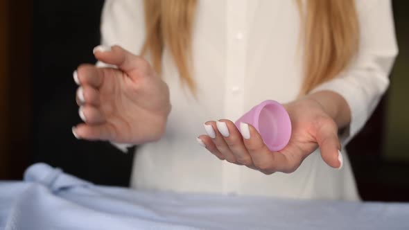 Close Up Menstrual Cup Latex Silicone in Girl Hands Holding Compress Folding alt