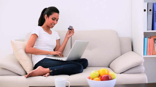 Attractive Woman Sitting On Couch Using Her Laptop 2