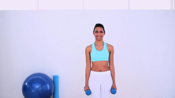 Fit Woman Standing And Lifting Hand Weights