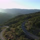 Aerial view of a car that rides on a mountain serpentine at dawn - VideoHive Item for Sale