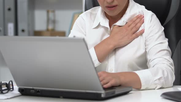 Lady Boss Working on Laptop Hardly Breathing, Chest Pain, Risk of Heart Attack