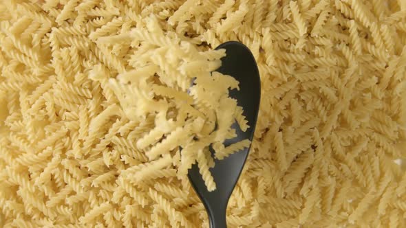 Spoon with a figural pasta (fusilli) falls on a figural pasta