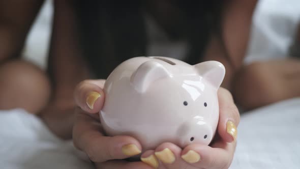Family Putting Coins Into Piggy Bank for the Future Savings. alt