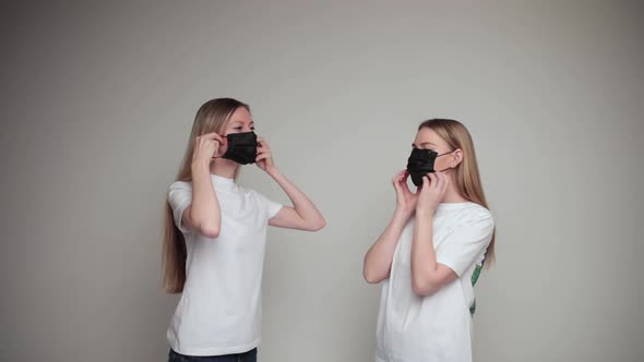 Two Young Beautiful Doctors Wear Black Medical Masks and Prepare for the Working Day