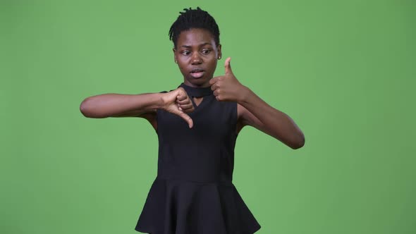 Young Beautiful African Businesswoman Choosing Between Thumbs Up and Thumbs Down