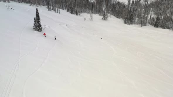 Aerial View of a Skier and Snowboarder Riding on a Snowy Slope.