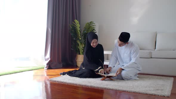 Handsome Muslim man teaching young woman read Quran 